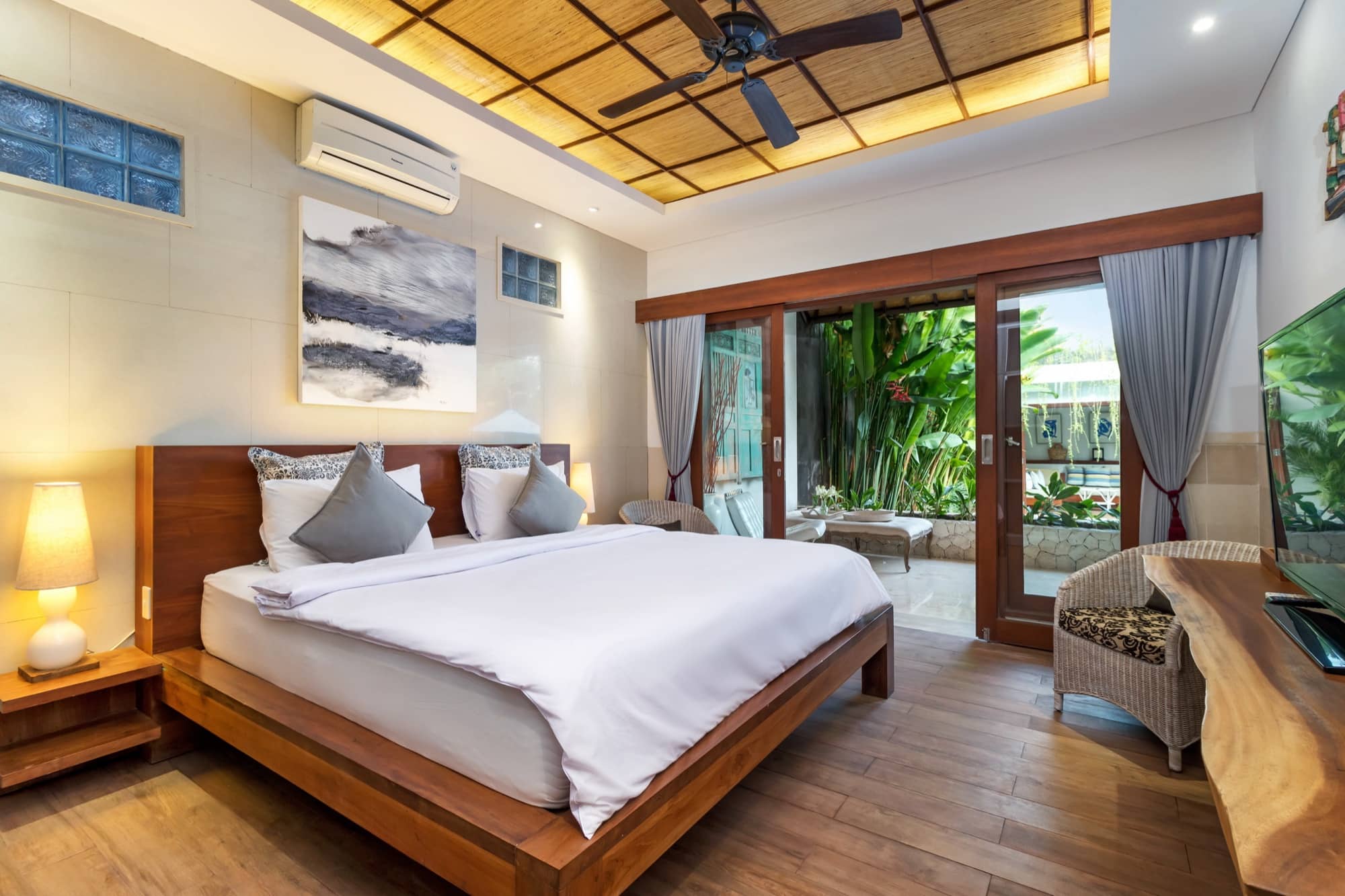 Villa Blue Bali — Bedroom 2, warm timber and white linen, garden view