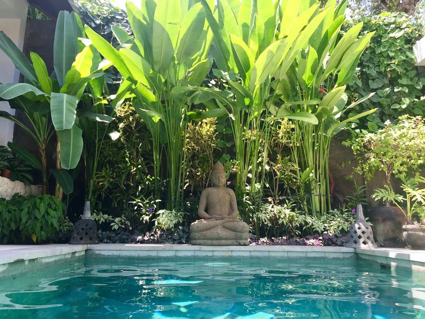 Villa Blue Bali — Buddha statue and tropical foliage above the pool