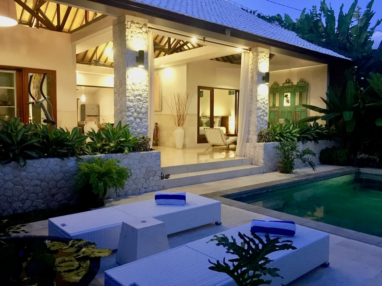 Villa Blue Bali — open living pavilion lit warmly at twilight