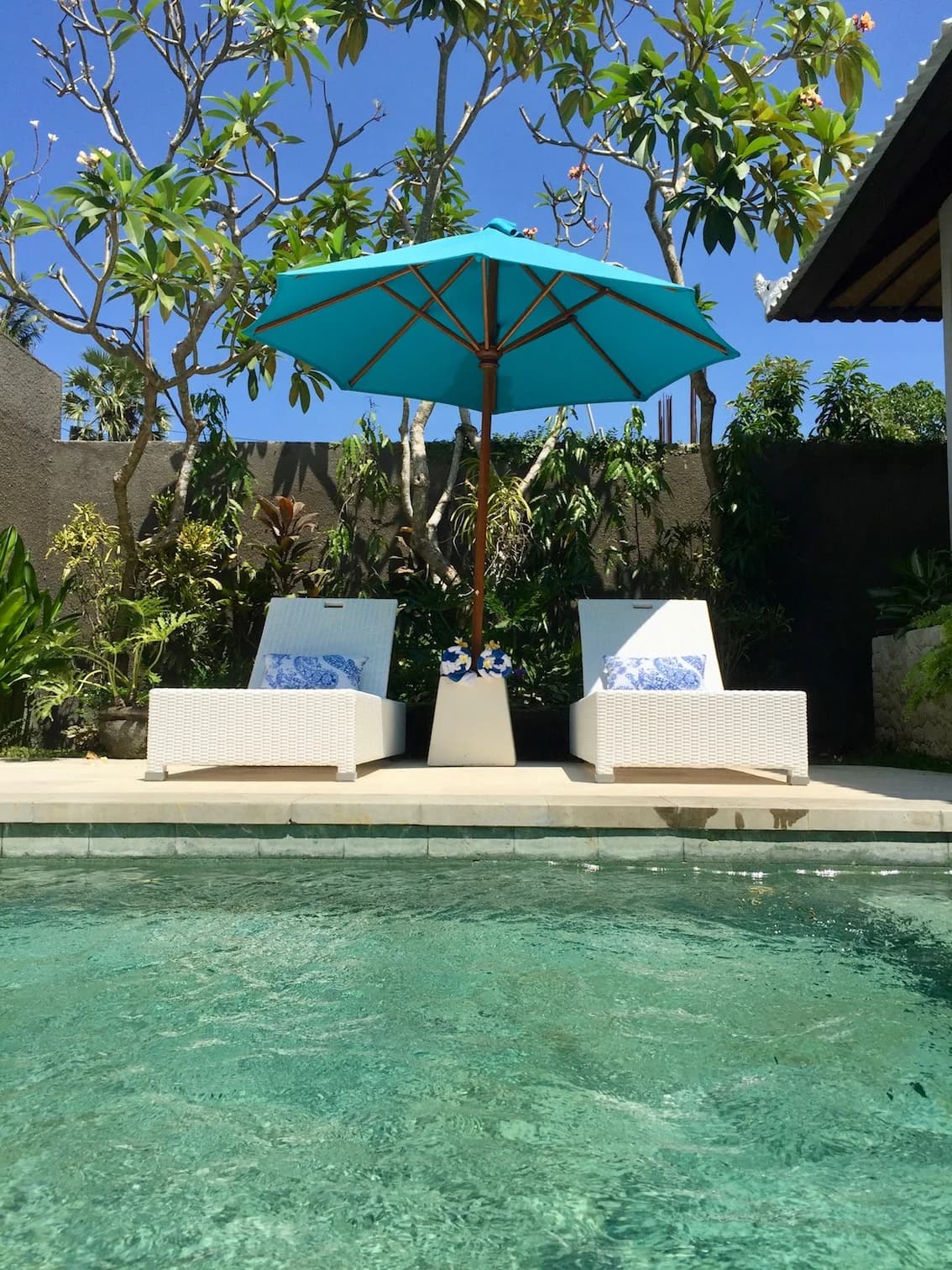 Villa Blue Bali — sun loungers and turquoise umbrella over the pool in afternoon light