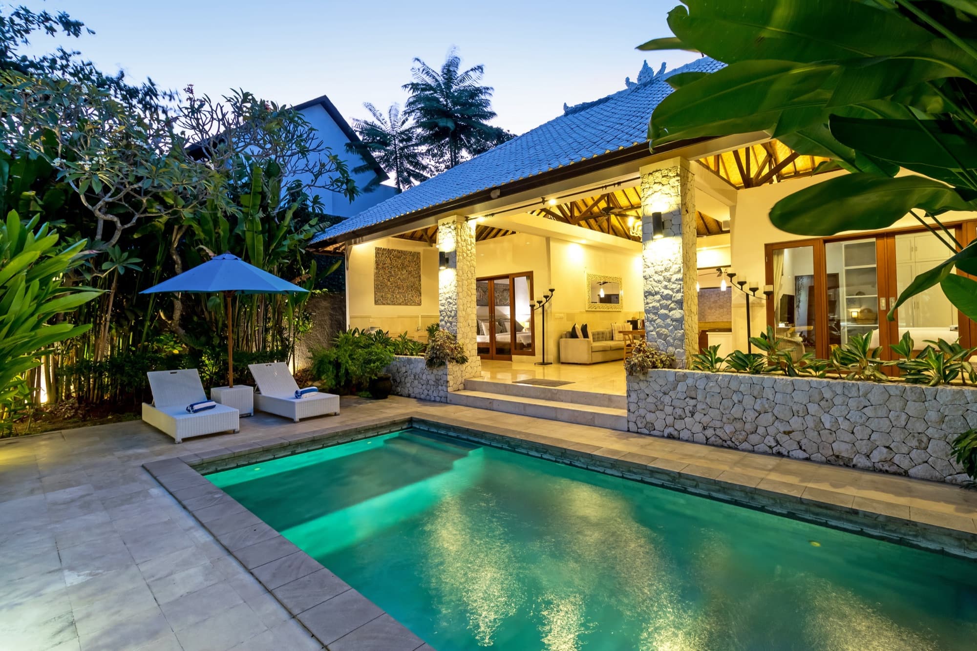 Villa Blue Bali — pool at blue-hour, palms overhead, open living room glowing inside
