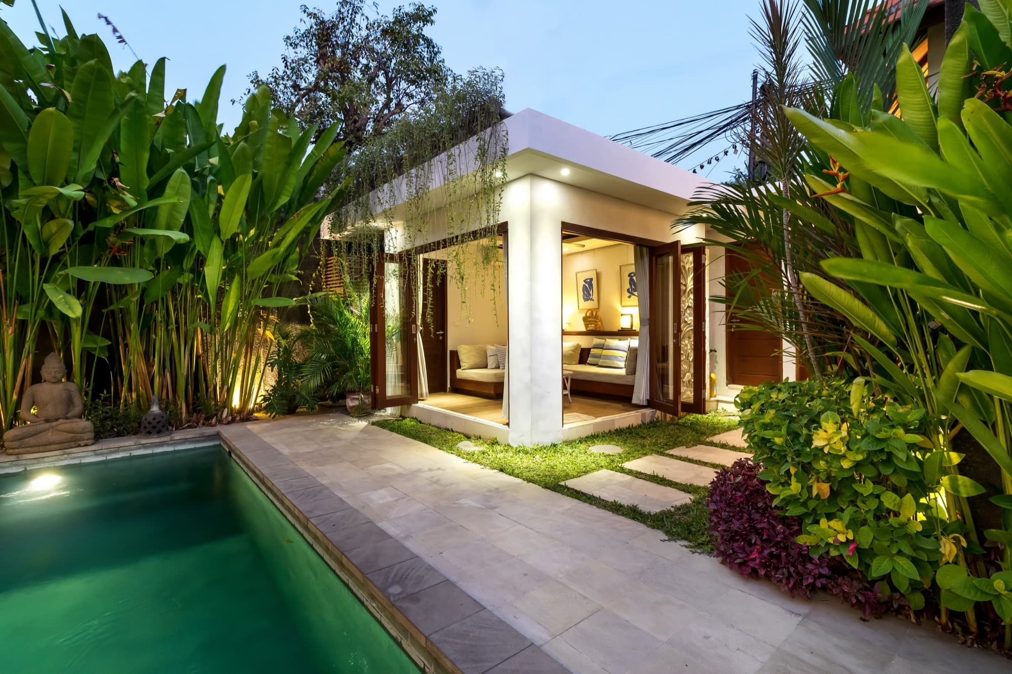 Villa Blue Bali — bale-style media lounge open to garden and pool at evening