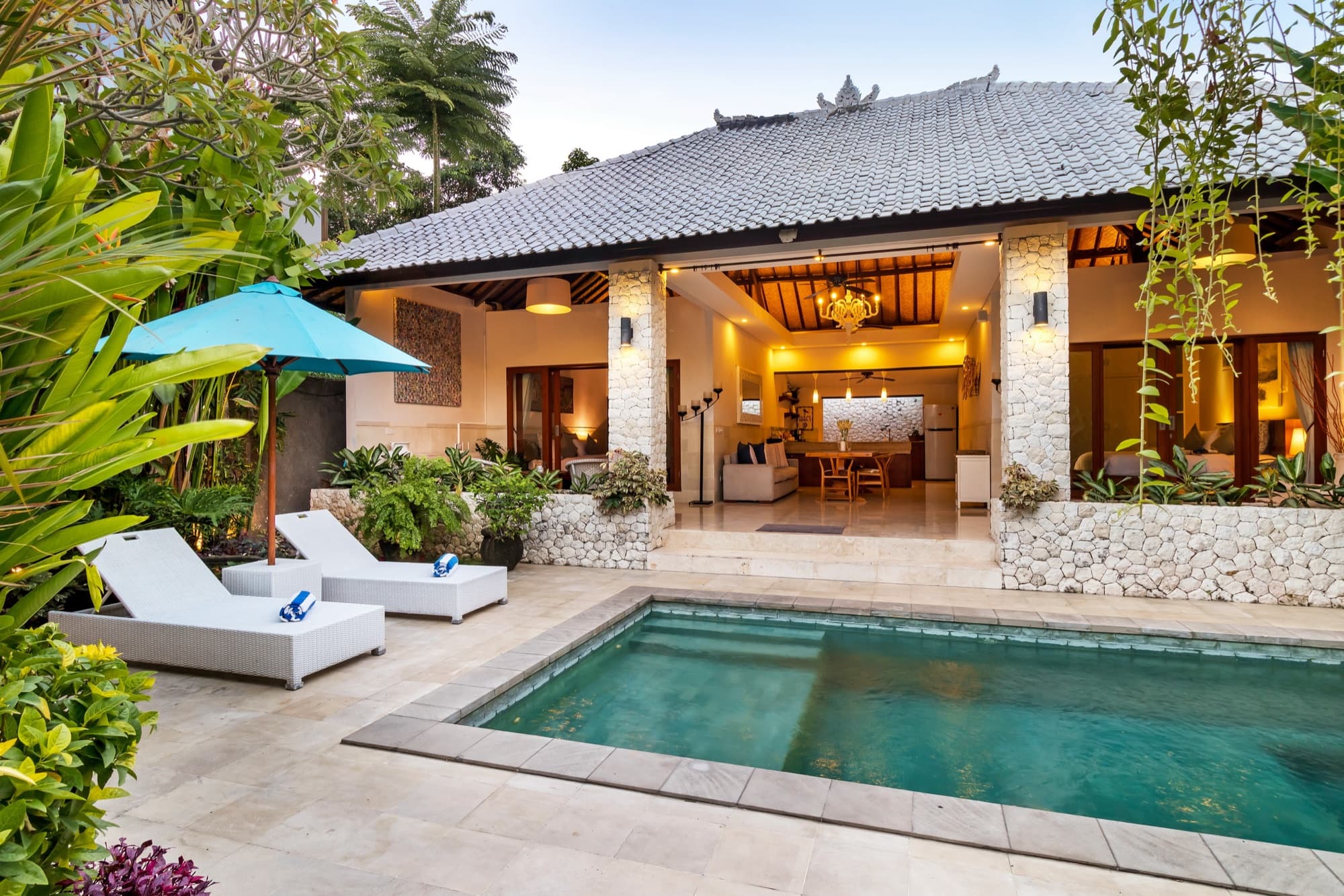 Villa Blue Bali — golden-hour view of pool and open living pavilion framed by tropical garden